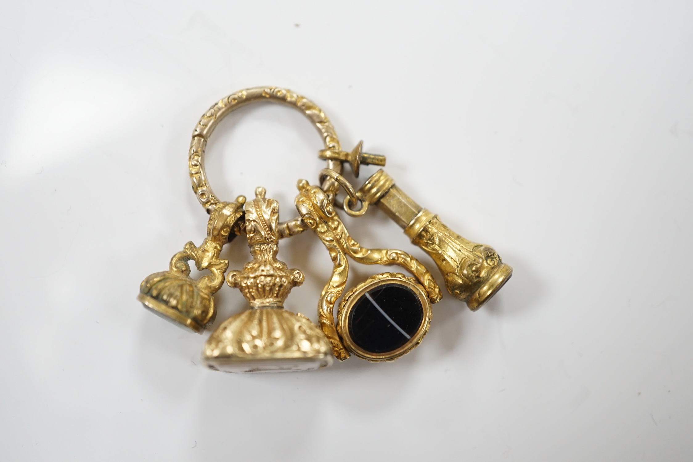 Three assorted 19th century yellow metal overlaid and chalcedony set fob seals and one other item, all mounted on a loop ring, largest approx. 20mm.